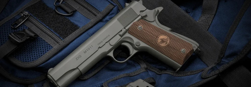 Pistolet TİSAŞ ZIG M1911 posé sur un sac tactique noir et bleu