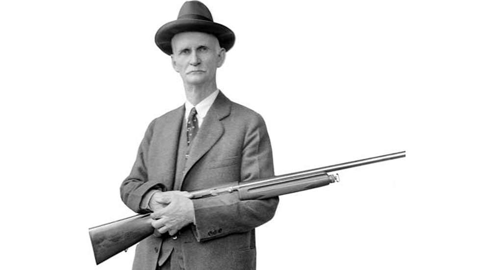 Portrait en noir et blanc de John Moses Browning tenant un fusil Browning Auto-5.