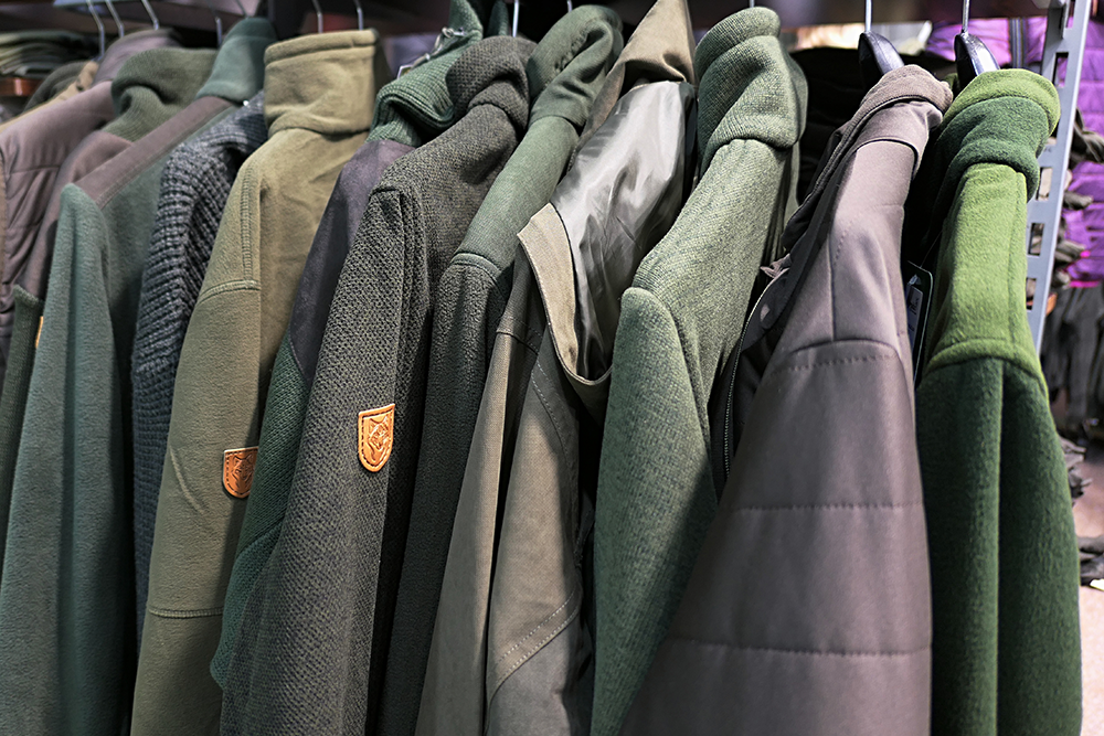 Vestes polaires de chasse en différentes teintes de vert, accrochées sur cintres