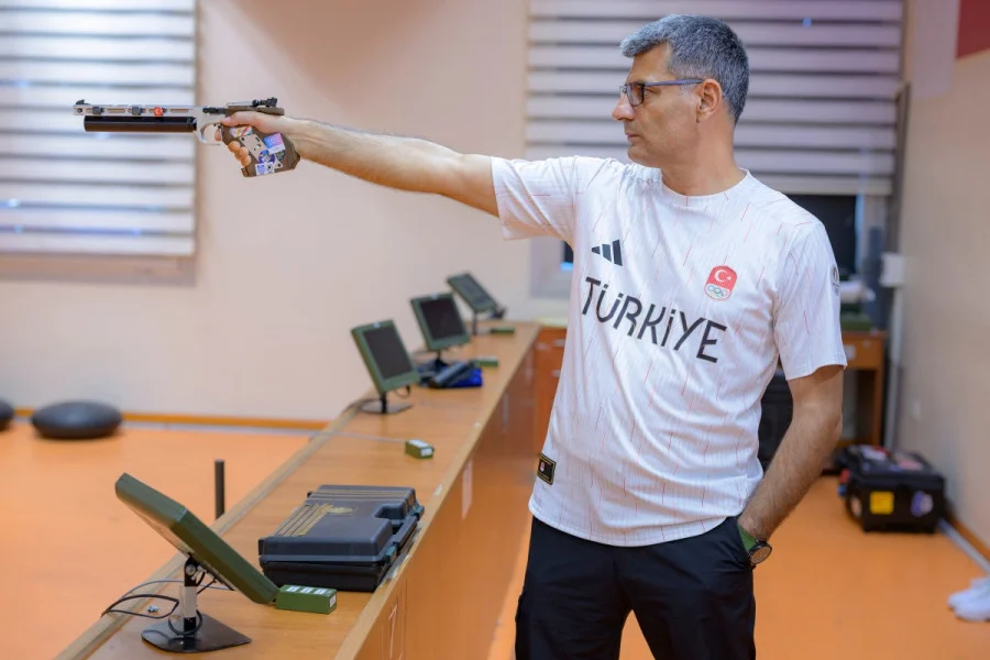 Tireur turc Yusuf Dikeç en position de tir à 10 mètres avec pistolet à air comprimé, bras tendu.