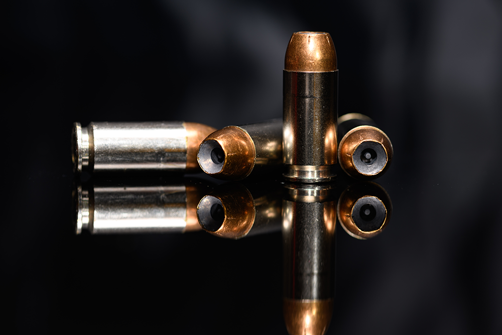 Cartouches de calibre .40 Smith et Wesson sur fond noir, avec ogives cuivrées et douilles métalliques, symbolisant la puissance et la précision du calibre.
