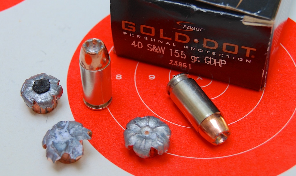 Cartouches Speer Gold Dot en calibre .40 Smith et Wesson, avec projectiles expansés après tir sur cible, illustrant l’efficacité des ogives JHP.
