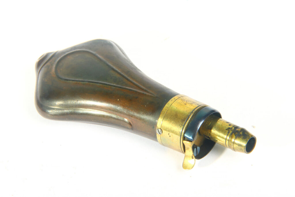 Poire à poudre en métal et laiton pour revolver à poudre noire utilisée pour le chargement d’un Remington 1858.