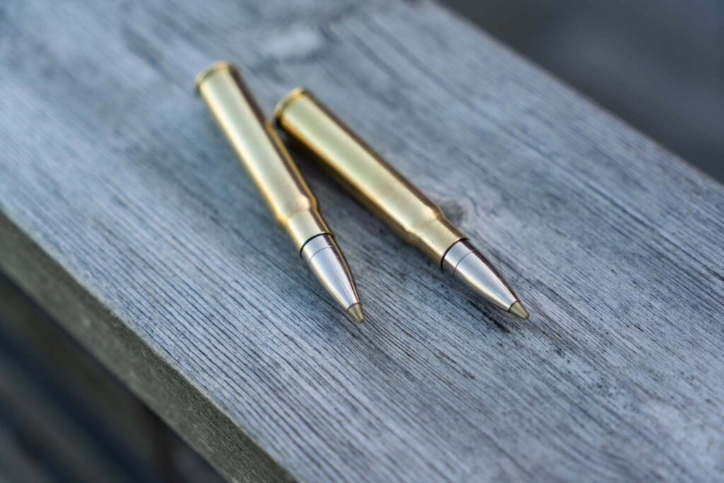 Deux cartouches de chasse Norma EVOSTRIKE sans plomb posées sur une surface en bois